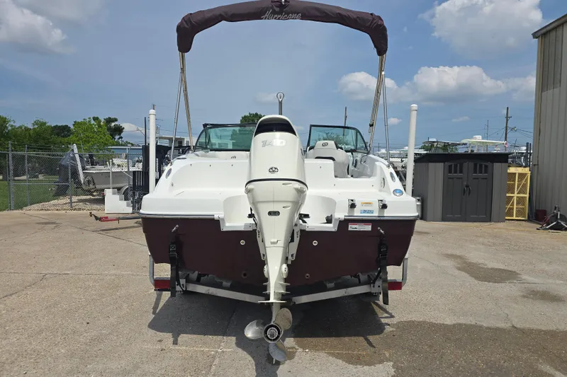 Slide: The Image of 2020 Hurricane SunDeck 187 OB boat with outboard motor, parked outdoors under a clear sky. - 6