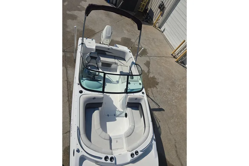 Slide: The Image of 2020 Hurricane SunDeck 187 OB boat with spacious seating and sleek design, docked outdoors. - 8