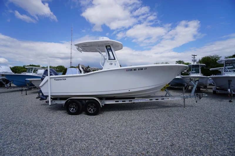 The Image of 2023 Tidewater 232 CC Adventure boat on trailer, parked outdoors under a blue sky. - 1