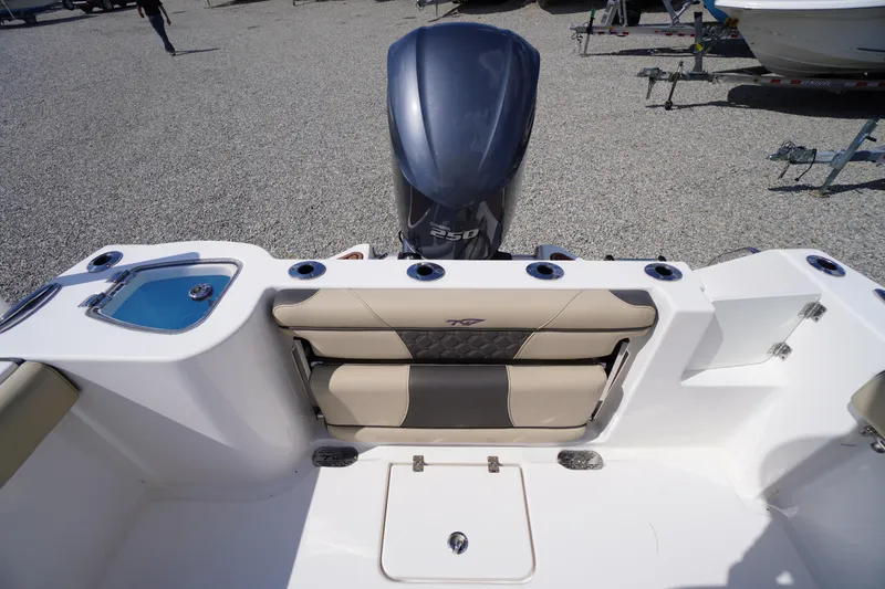 Slide: The Image of 2023 Tidewater 232 CC Adventure boat interior with seating and motor view. - 11