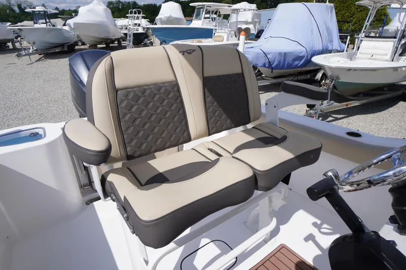 Slide: The Image of 2023 Tidewater 232 CC Adventure boat seats with armrests in a marina setting. - 16