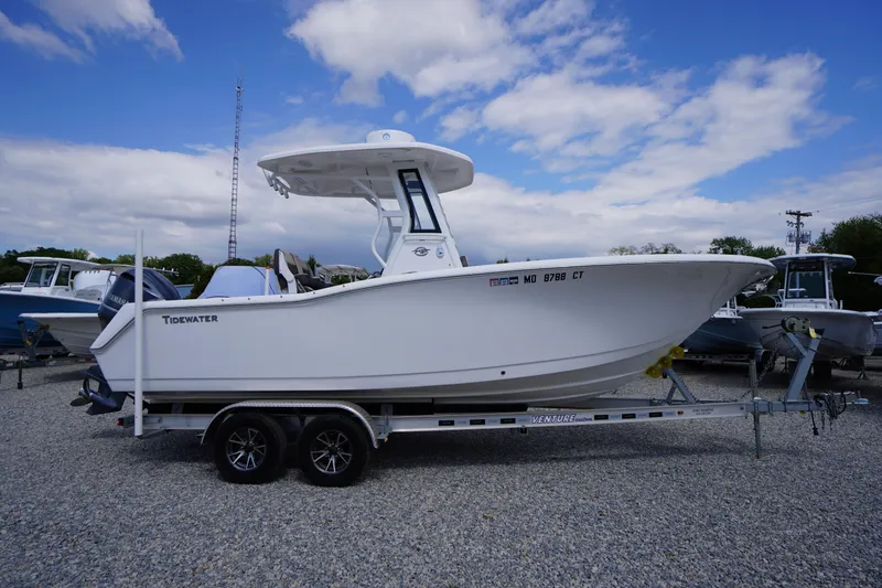 Slide: The Image of 2023 Tidewater 232 CC Adventure boat on trailer under blue sky. - 2