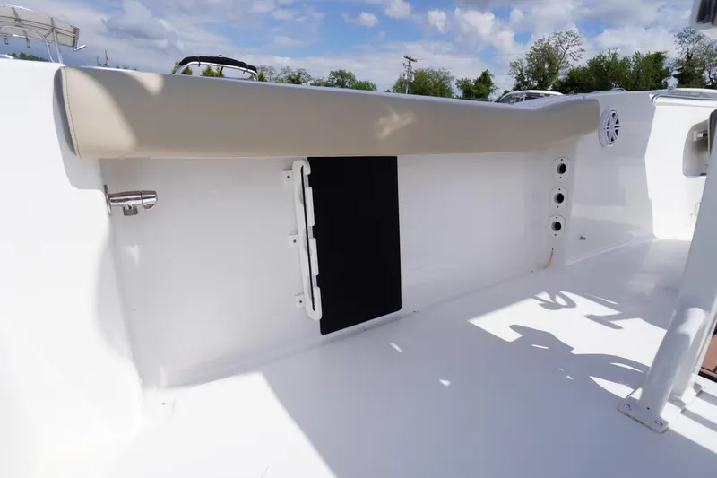 Slide: The Image of 2023 Tidewater 232 CC Adventure boat interior with cushioned seating and storage compartment. - 20