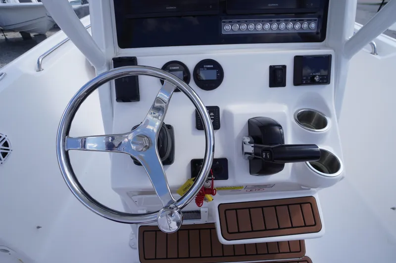 Slide: The Image of 2023 Tidewater 232 CC Adventure boat console with steering wheel and controls. - 28