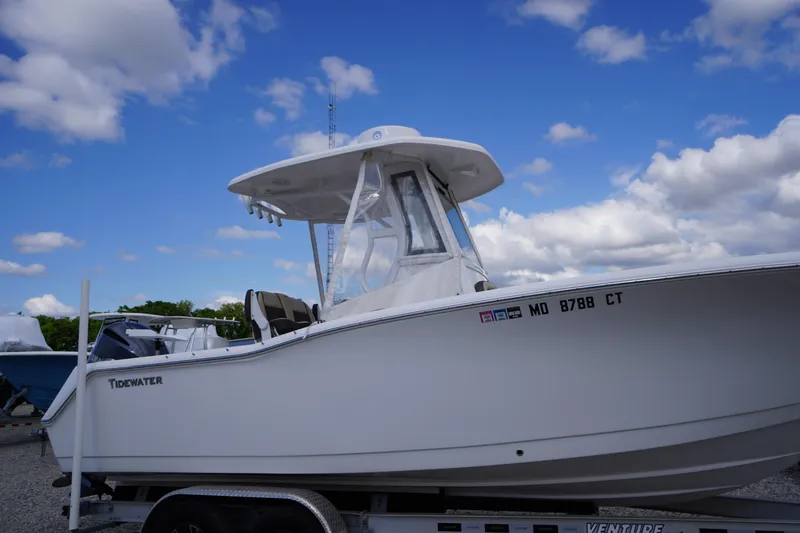 Slide: The Image of 2023 Tidewater 232 CC Adventure boat on trailer under blue sky. - 3