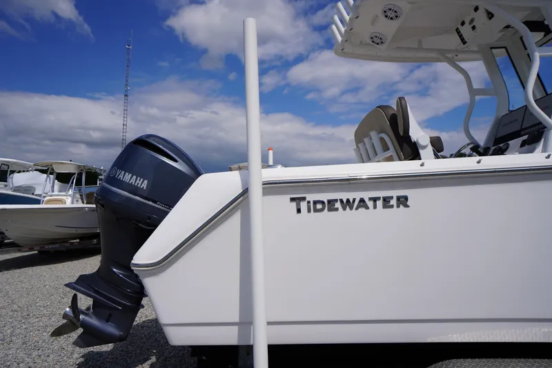 Slide: The Image of 2023 Tidewater 232 CC Adventure boat with Yamaha engine, parked outdoors under blue sky. - 4
