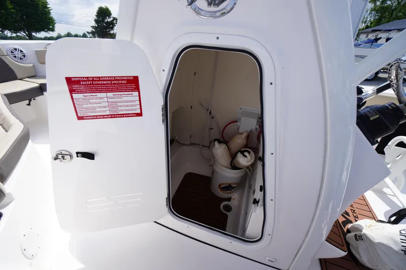 Slide: The Image of 2023 Tidewater 232 CC Adventure boat storage compartment with safety notice and equipment. - 43