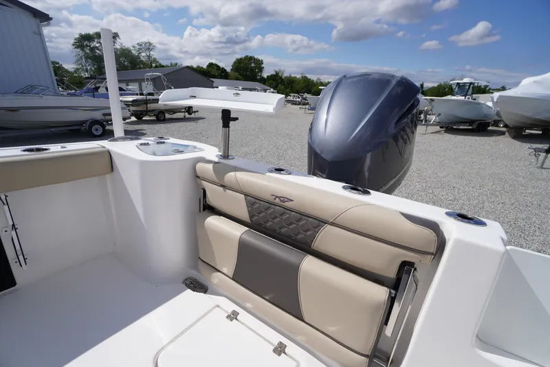 Slide: The Image of 2023 Tidewater 232 CC Adventure boat interior with cushioned seating and outboard motor. - 49