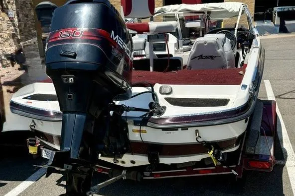 Slide: The Image of 1996 Astro 18 FSX boat with Mercury 150 outboard motor, parked on a trailer. - 4