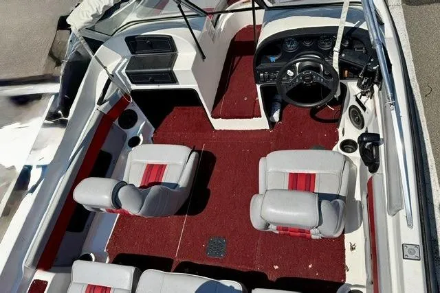 Slide: The Image of Interior of a 1996 Astro 18 FSX boat with red carpet and gray seats. - 6