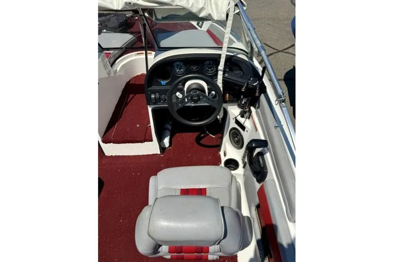 Slide: The Image of 1996 Astro 18 FSX boat interior with red carpet and steering console. - 7