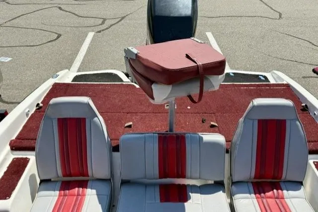 Slide: The Image of 1996 Astro 18 FSX boat interior with red and white seating, parked on pavement. - 8