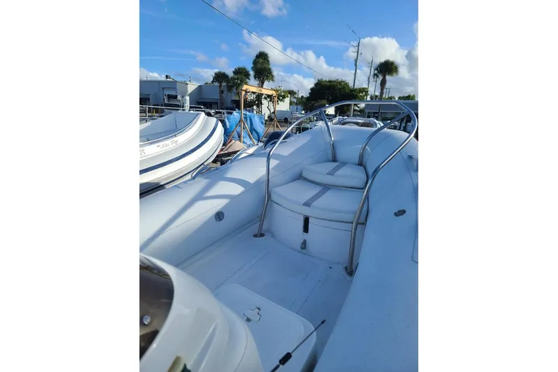 Slide: The Image of 2009 Nautica 15 DL boat interior with white seating and metal railings under blue sky. - 4
