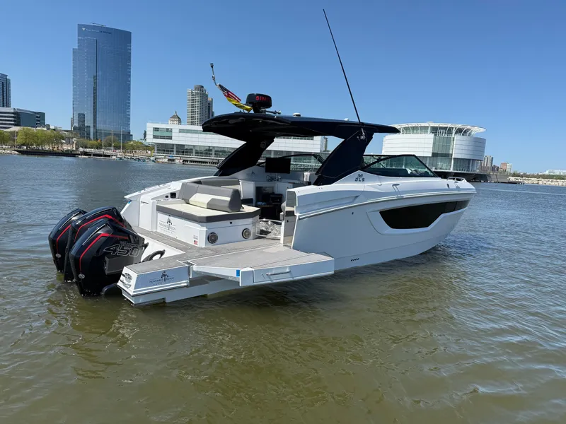 Slide: The Image of 2021 Cruisers Yachts 38 GLS on water with city buildings backdrop. - 2