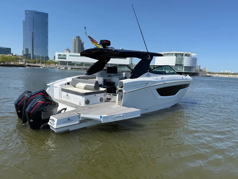 Slide: The Image of 2021 Cruisers Yachts 38 GLS on calm water with modern skyline backdrop. - 5