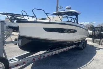 Slide: The Image of 2024 Navan S30 boat on trailer, sleek design, parked outdoors under clear blue sky. - 2