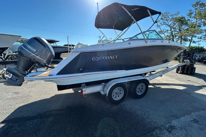 Slide: The Image of 2018 Cobalt 25SC boat on trailer with Yamaha outboard motor, parked outdoors. - 10