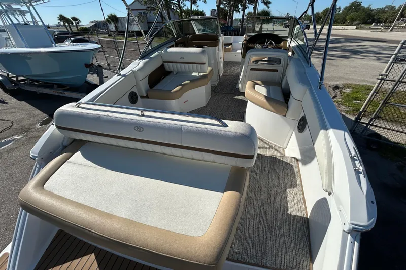 Slide: The Image of 2018 Cobalt 25SC boat interior with beige seating and carpeted flooring. - 13