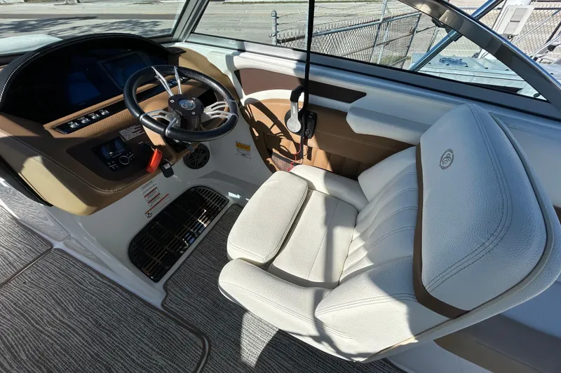 Slide: The Image of Interior of a 2018 Cobalt 25SC boat featuring a sleek steering wheel and comfortable seating. - 21