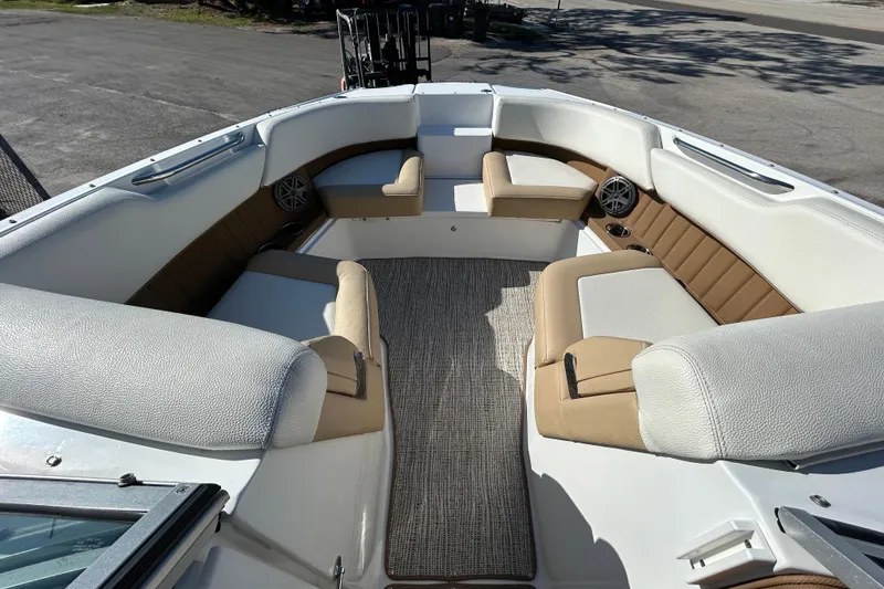 Slide: The Image of 2018 Cobalt 25SC boat interior with beige and white seating, outdoor setting. - 24