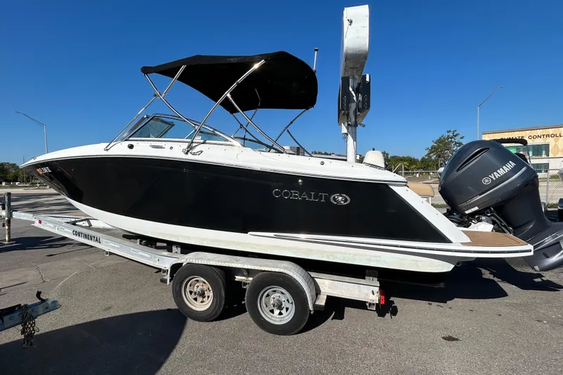 Slide: The Image of 2018 Cobalt 25SC boat on trailer with Yamaha outboard motor, parked outdoors. - 3