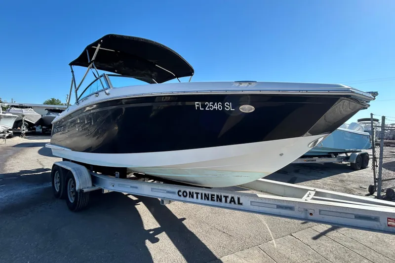 Slide: The Image of 2018 Cobalt 25SC boat on trailer, black hull, sunny day, Continental trailer. - 8