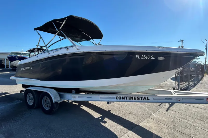 Slide: The Image of 2018 Cobalt 25SC boat on trailer, black hull, sunny day. - 9