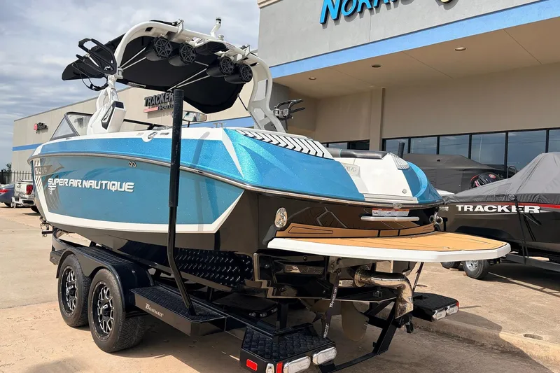 Slide: The Image of 2017 Nautique Super Air Nautique G23 boat in blue, parked on a trailer outside a dealership. - 7