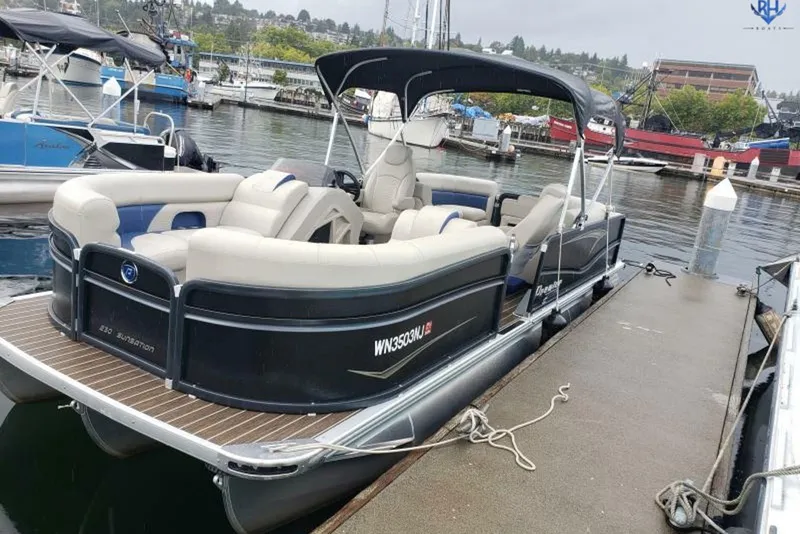 Slide: The Image of 2022 Premier 230 Sunsation RF - CL pontoon boat docked at a marina. - 1