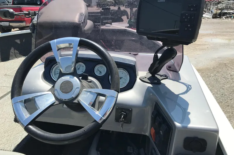 Slide: The Image of 2014 Lowe Fishing Machine 165SC Pro dashboard with steering wheel and Garmin device. - 12