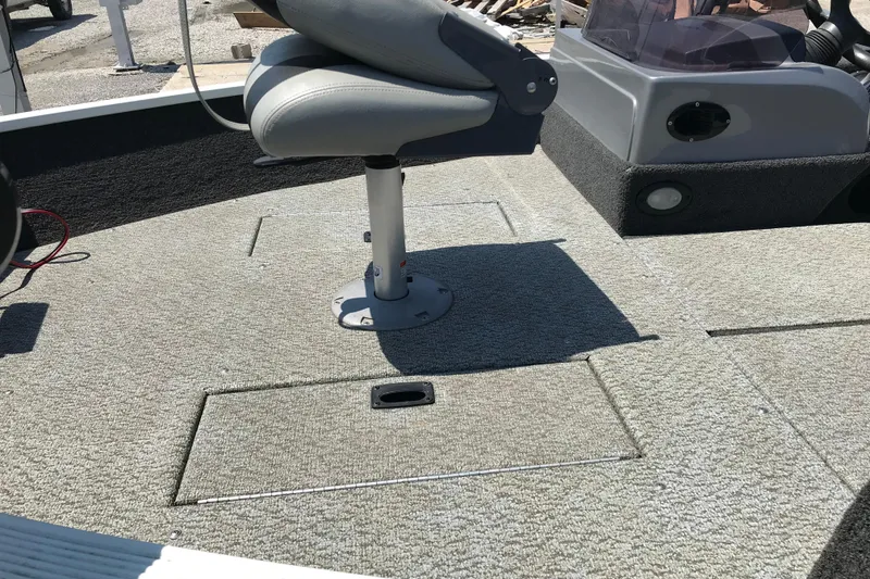 Slide: The Image of 2014 Lowe Fishing Machine 165SC Pro boat interior with swivel seat and carpeted deck. - 17