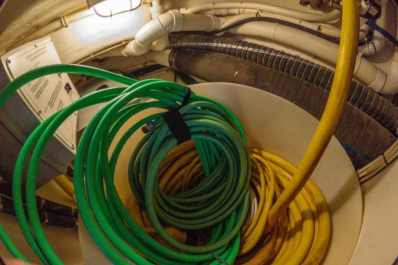 Slide: The Image of Coiled hoses in the engine room of a 2005 West Bay 86 Raised Pilothouse Motor Yacht. - 136
