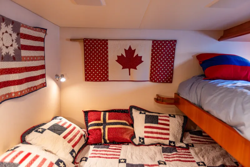 Slide: The Image of Cozy yacht cabin with patriotic quilts and flags, featuring bunk beds. - 85