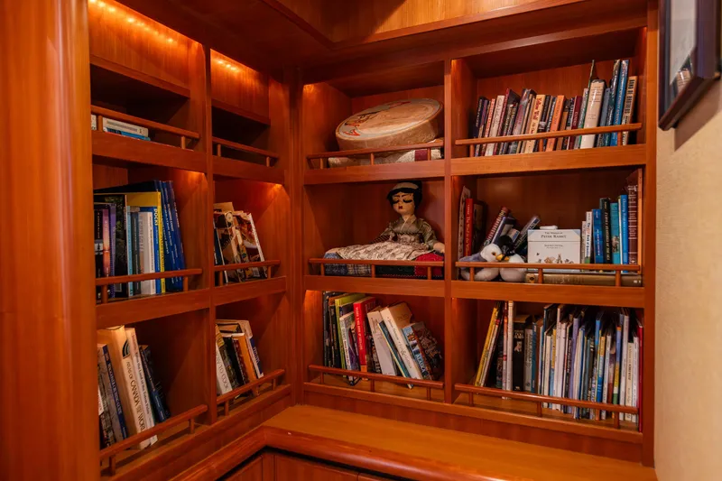 Slide: The Image of Wooden bookshelf with books and decor on a 2005 West Bay 86 Raised Pilothouse Motor Yacht. - 54