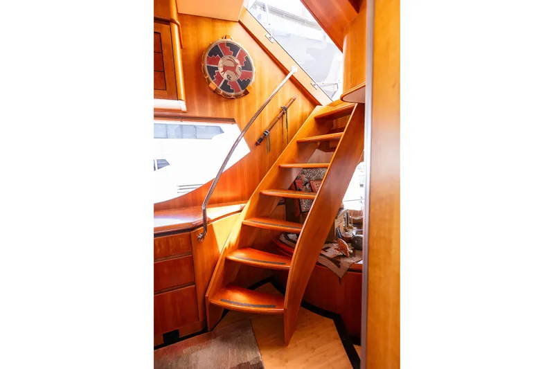Slide: The Image of Interior staircase of 2005 West Bay 86 Raised Pilothouse Motor Yacht, featuring wooden steps. - 31
