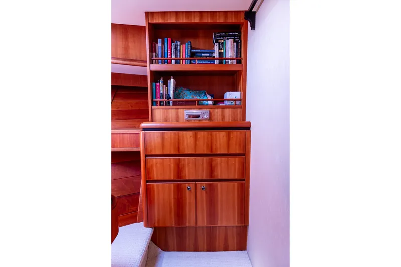 Slide: The Image of Wooden cabinet with books and decor in 2005 West Bay 86 Raised Pilothouse Motor Yacht. - 86
