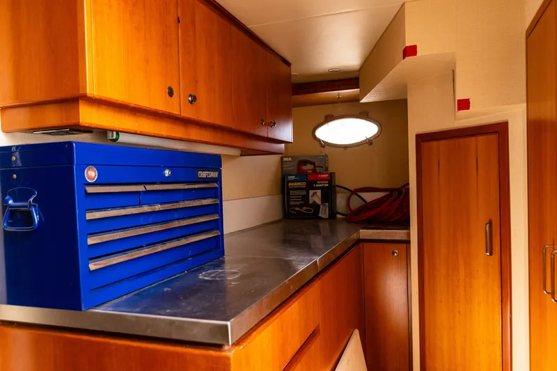 Slide: The Image of Interior of 2005 West Bay 86 Yacht with tool chest and wooden cabinetry. - 130