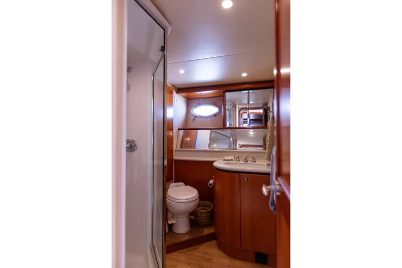 Slide: The Image of Luxurious bathroom in 2005 West Bay 86 Raised Pilothouse Motor Yacht, featuring wood cabinetry and modern fixtures. - 88