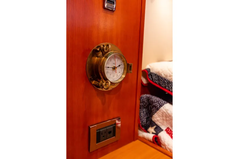 Slide: The Image of Brass clock on wooden panel in 2005 West Bay 86 Raised Pilothouse Motor Yacht interior. - 91