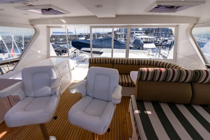 Slide: The Image of Interior of 2005 West Bay 86 Raised Pilothouse Motor Yacht with seating and marina view. - 98
