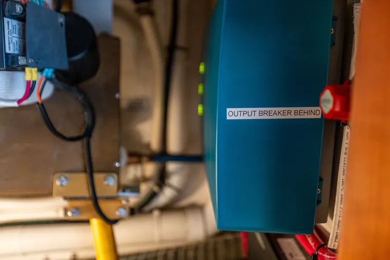 Slide: The Image of Electrical panel labeled "Output Breaker Behind" on 2005 West Bay 86 Motor Yacht. - 133