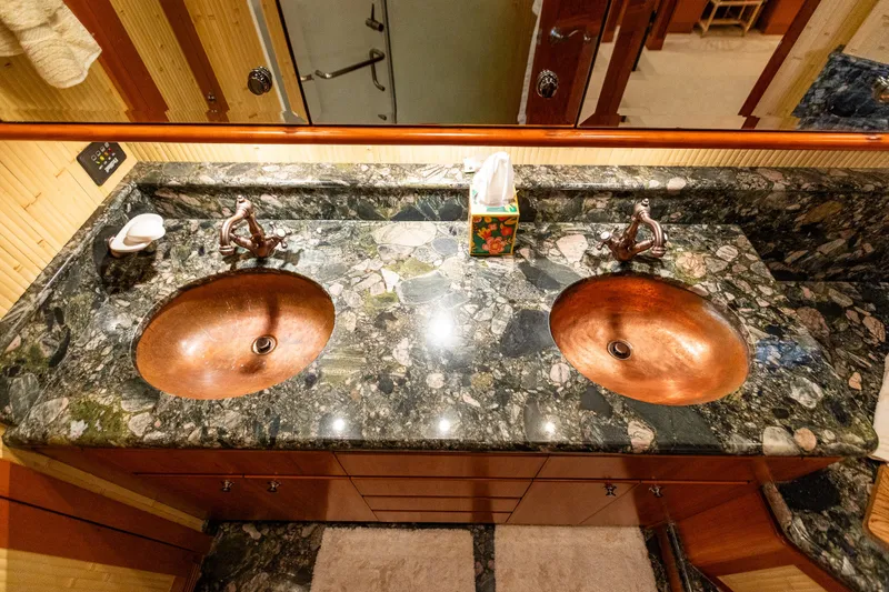 Slide: The Image of Luxurious bathroom with dual copper sinks and marble countertop on a 2005 West Bay yacht. - 75