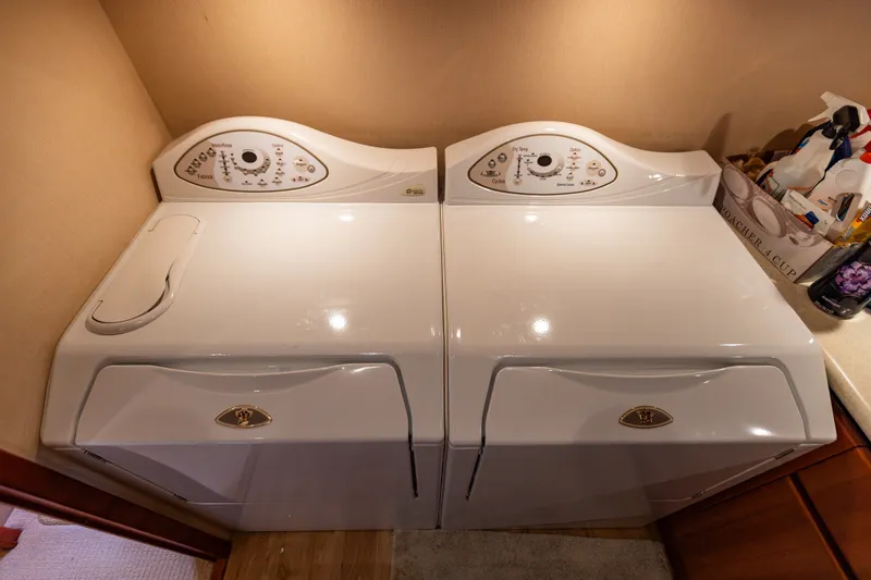 Slide: The Image of Laundry area with washer and dryer on 2005 West Bay 86 Raised Pilothouse Motor Yacht. - 93