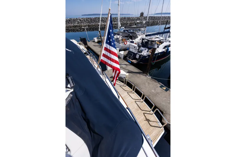 Slide: The Image of American flag on 2005 West Bay 86 Raised Pilothouse Motor Yacht docked at marina. - 145
