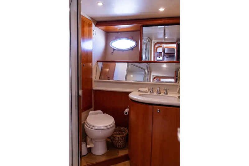 Slide: The Image of Luxurious bathroom in 2005 West Bay 86 Raised Pilothouse Motor Yacht, featuring elegant wood finishes. - 89