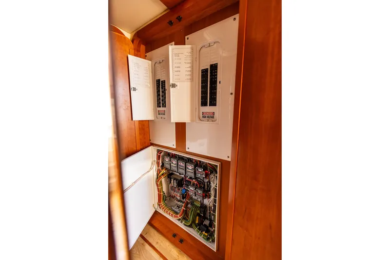 Slide: The Image of Electrical panel inside 2005 West Bay 86 Raised Pilothouse Motor Yacht, showcasing wiring and circuit breakers. - 112