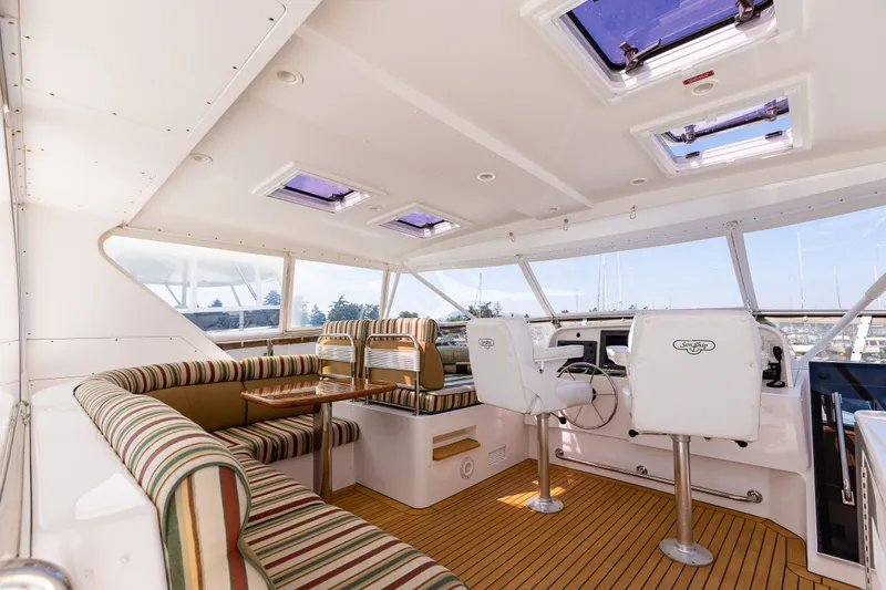 Slide: The Image of Luxurious interior of 2005 West Bay 86 Raised Pilothouse Motor Yacht with striped seating and helm. - 95