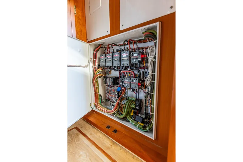 Slide: The Image of Electrical panel inside 2005 West Bay 86 Raised Pilothouse Motor Yacht, showcasing wiring and components. - 128
