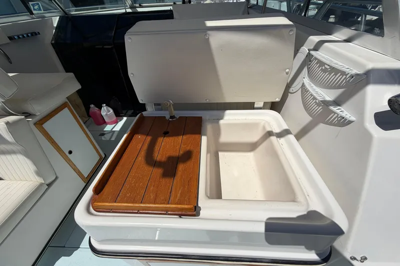 Slide: The Image of 1985 Formula 31 Performance Cruiser sink area with wooden cover and storage shelves. - 24