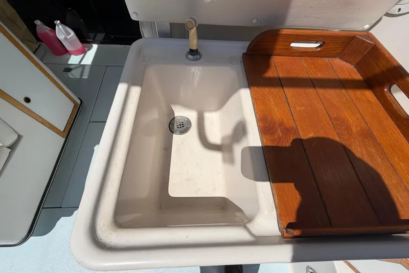 Slide: The Image of 1985 Formula 31 Performance Cruiser sink with wooden cover and faucet. - 25